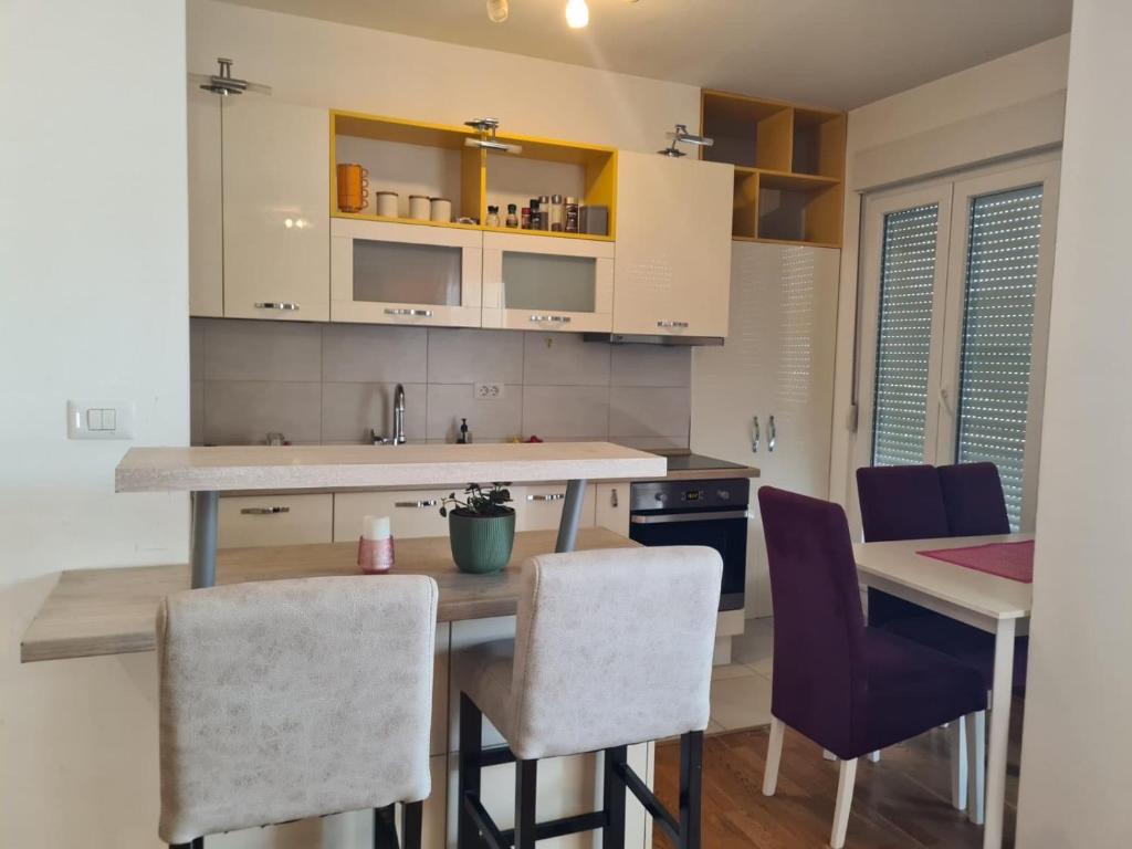 Una cocina con una mesa y algunas sillas. en Apartman Natalia, en Podgorica