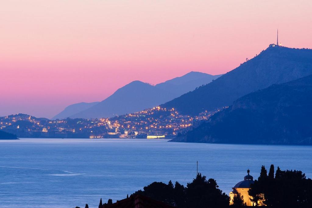 a view of a lake and mountains at sunset at Apartments Anuška in Cavtat