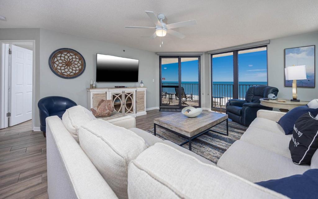 un soggiorno con un divano e una TV di Phoenix VI 6803 condo a Orange Beach