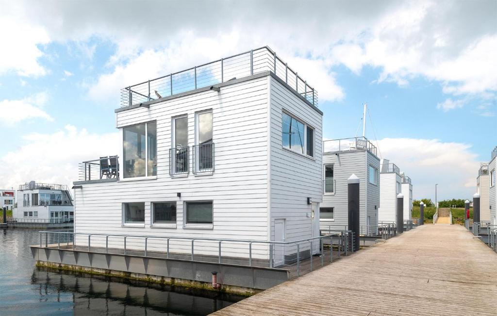 een wit huis op een dok naast het water bij Sutsche in Olpenitz