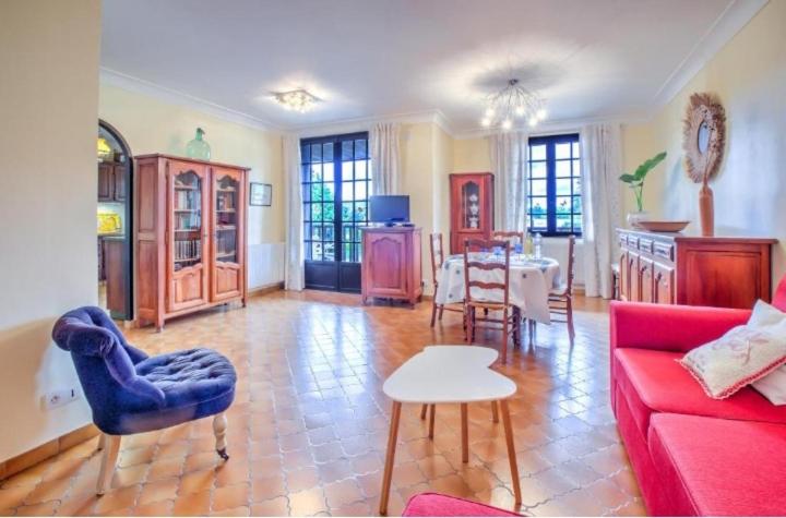 un salon avec un canapé rouge et une table dans l'établissement La Maison de Rosyne, à Aubas