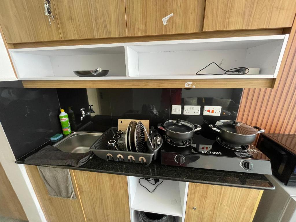 a kitchen with a stove with pots and pans on it at Bliss Apartment Tsavo Fedha near JKIA in Nairobi