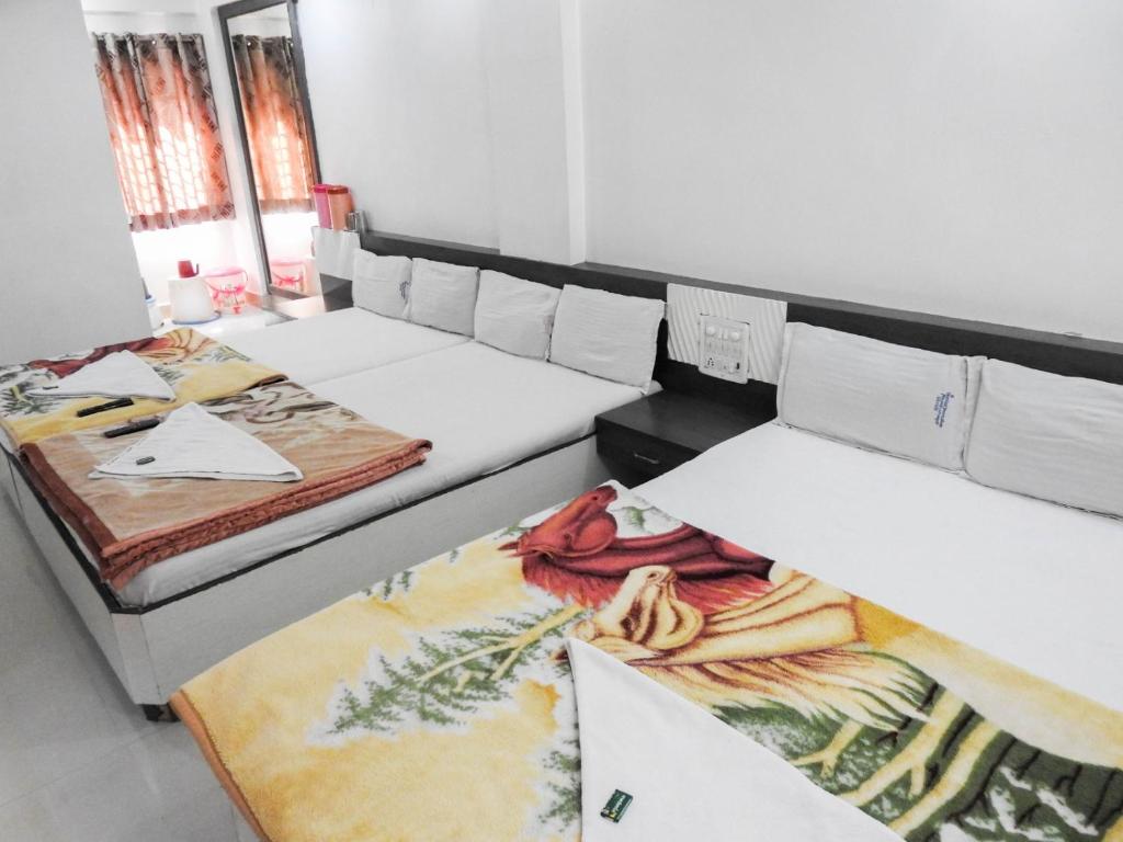 Postel nebo postele na pokoji v ubytování Hotel Shri Sai Darshan