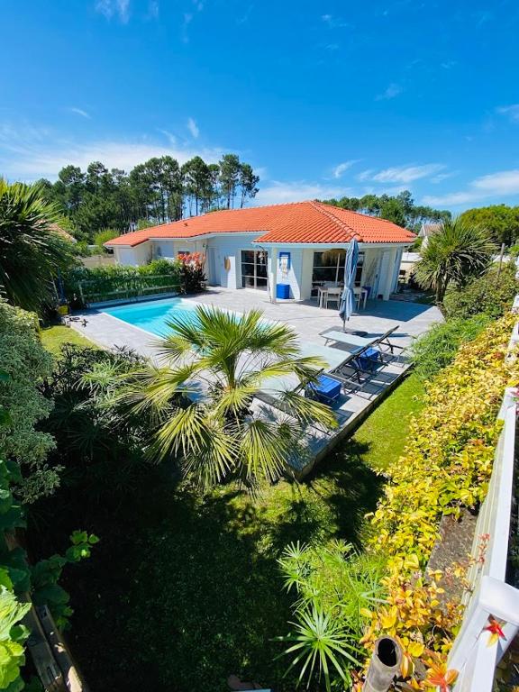 une vue aérienne d'une maison avec piscine dans l'établissement Biscaraibes, à Biscarrosse