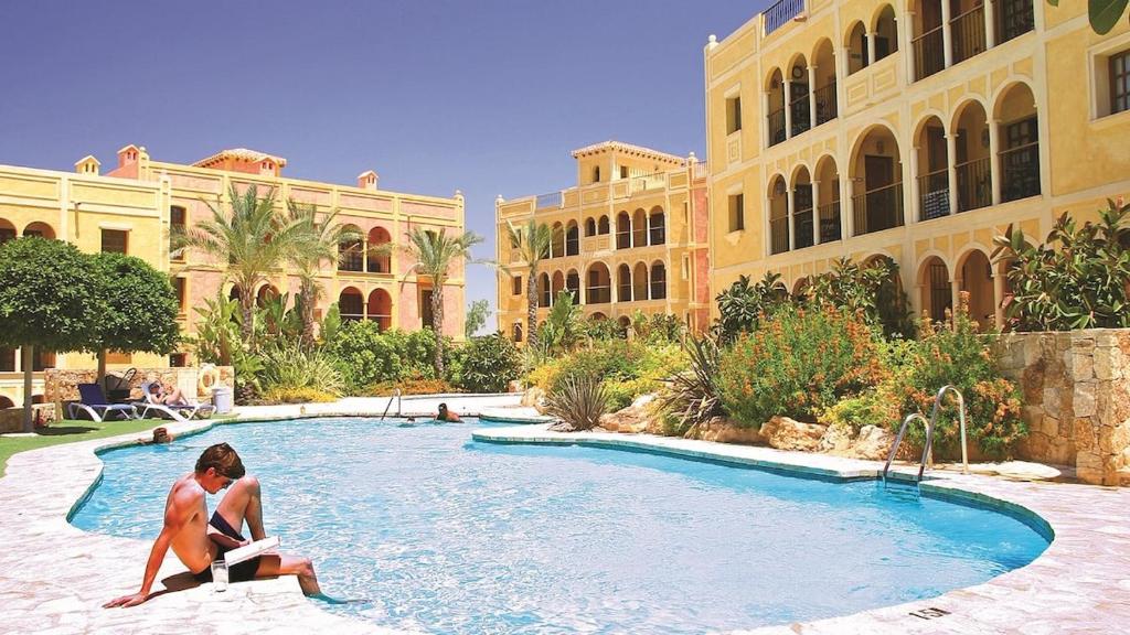 two women sitting in a swimming pool in a resort at Desert Springs award-winning Golf Resort apartment in La Hoya del Camaino