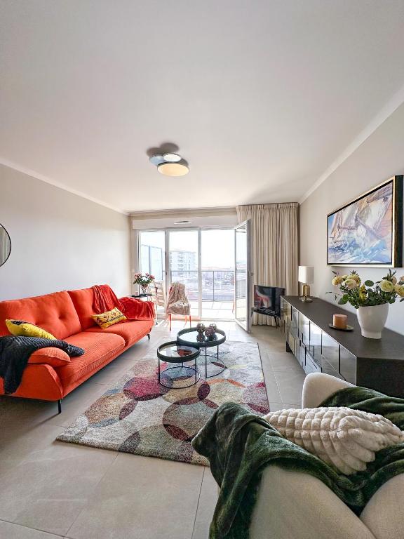 un salon avec un canapé rouge et une table dans l'établissement Appartement Alchimy, à Antibes