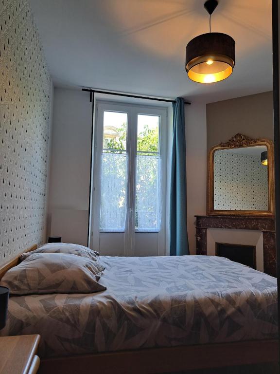 une chambre avec un lit, une fenêtre et un miroir dans l'établissement Art Nouveau & Nancy Thermal - Appartement F2 paisible de qualité, à Nancy