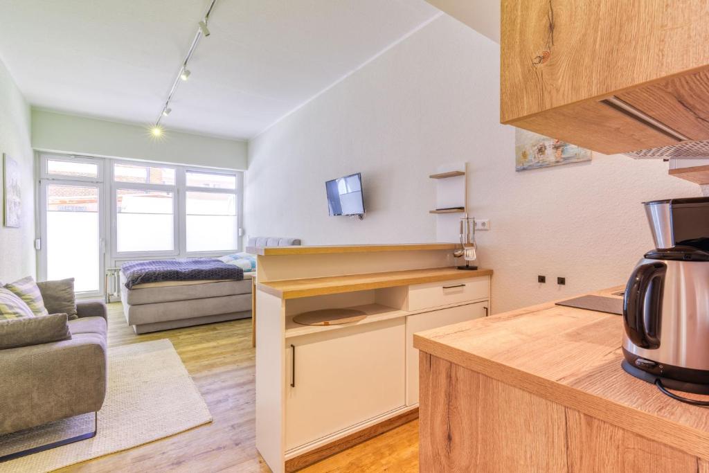 a kitchen and living room with a bed in a room at Alte Teestube in Norderney
