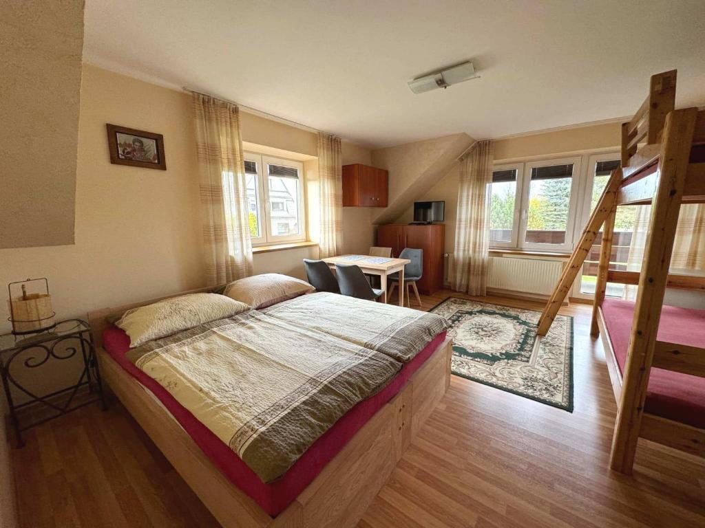 a bedroom with a bed and a dining room at Pod Jednym Dachem in Skawa