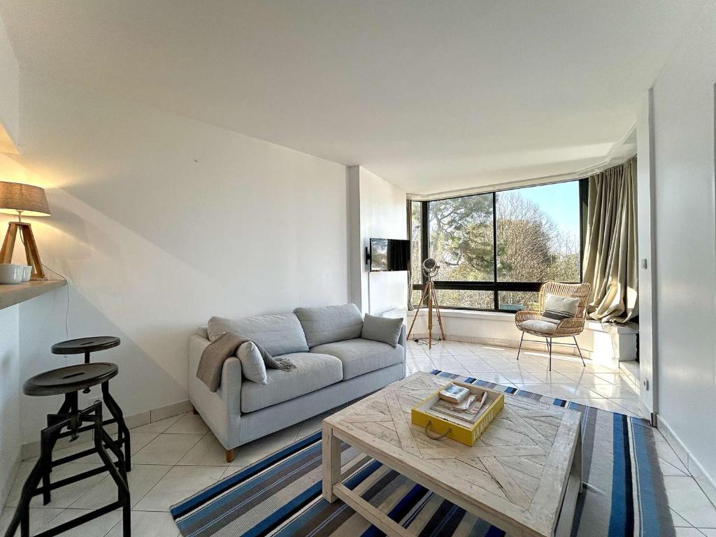 un salon avec un canapé et une table dans l'établissement Appartement calme avec terrasse à 2 pas de la plage Benoît, 2 pièces, 4 couchages, La Baule - FR-1-245-103, à La Baule