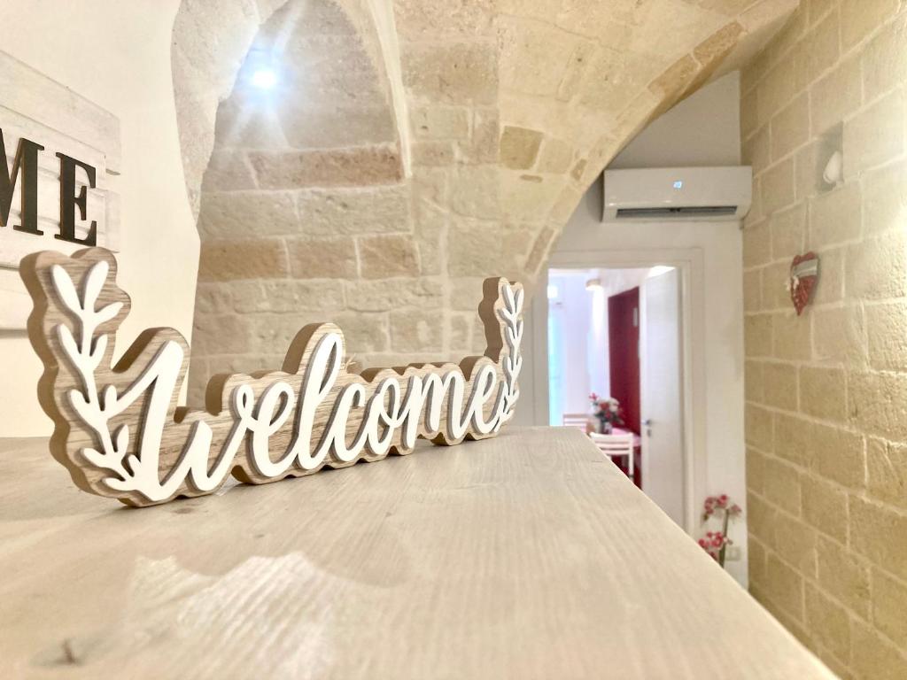 a sign that reads wine adventure sitting on a bed at Antica Pietra in Polignano a Mare