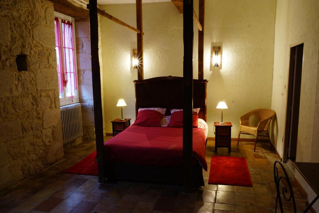 a bedroom with a four poster bed with red sheets at Un Coin de Paradis in Cologne