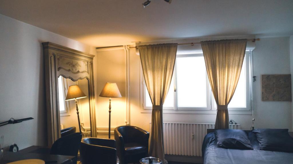 une chambre avec un lit et une fenêtre avec des rideaux dans l'établissement Studio Caen quartier historique, à Caen