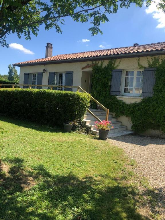 une maison blanche avec une terrasse couverte et une cour dans l'établissement Villa Buff-ô-T'iu - 3 chambres, à Courgeac