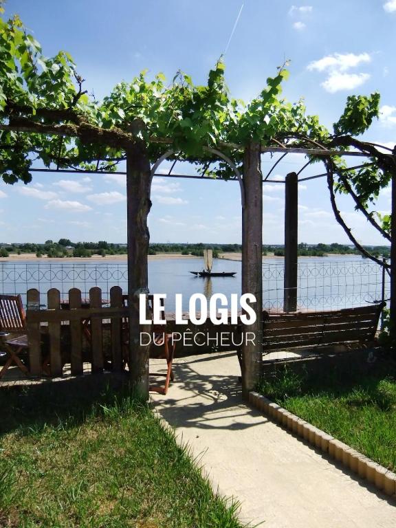 un parc avec deux bancs près d'un lac dans l'établissement Le Logis du pêcheur, à Ingrandes