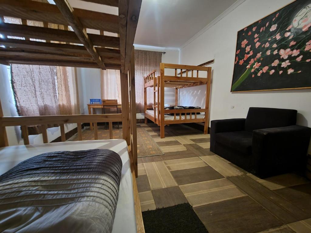 a bedroom with a bunk bed and a living room at Safari Junction Backpackers hostel in Iringa