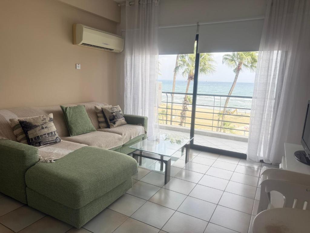 a living room with a couch and a view of the ocean at Krasas Beach Apartments in Larnaka