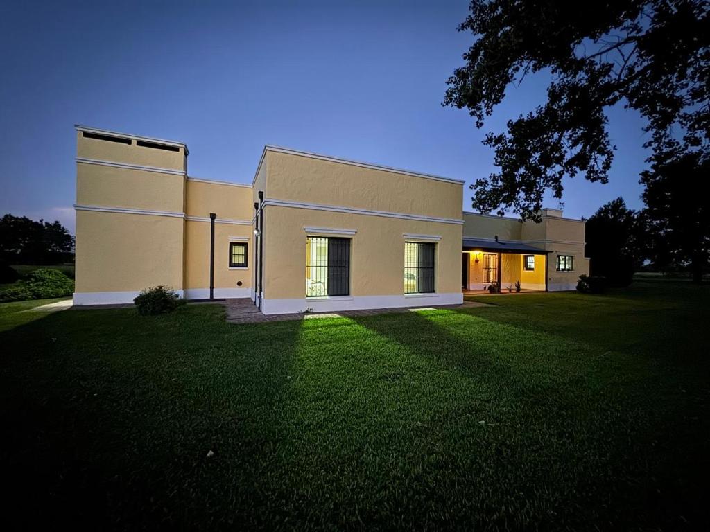 a large building with a grass yard in front of it at Estancia El Sosiego in Gualeguay