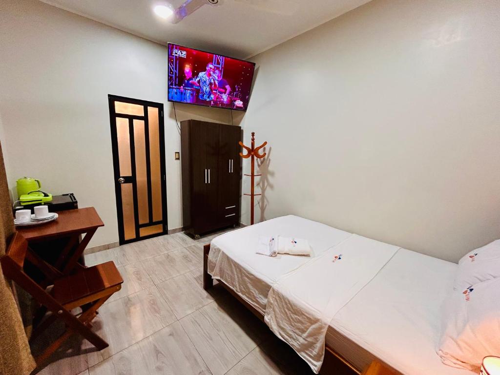 a bedroom with a bed and a tv on the wall at Habitación Céntrica en Iquitos - Casa Alemi 9 in Iquitos