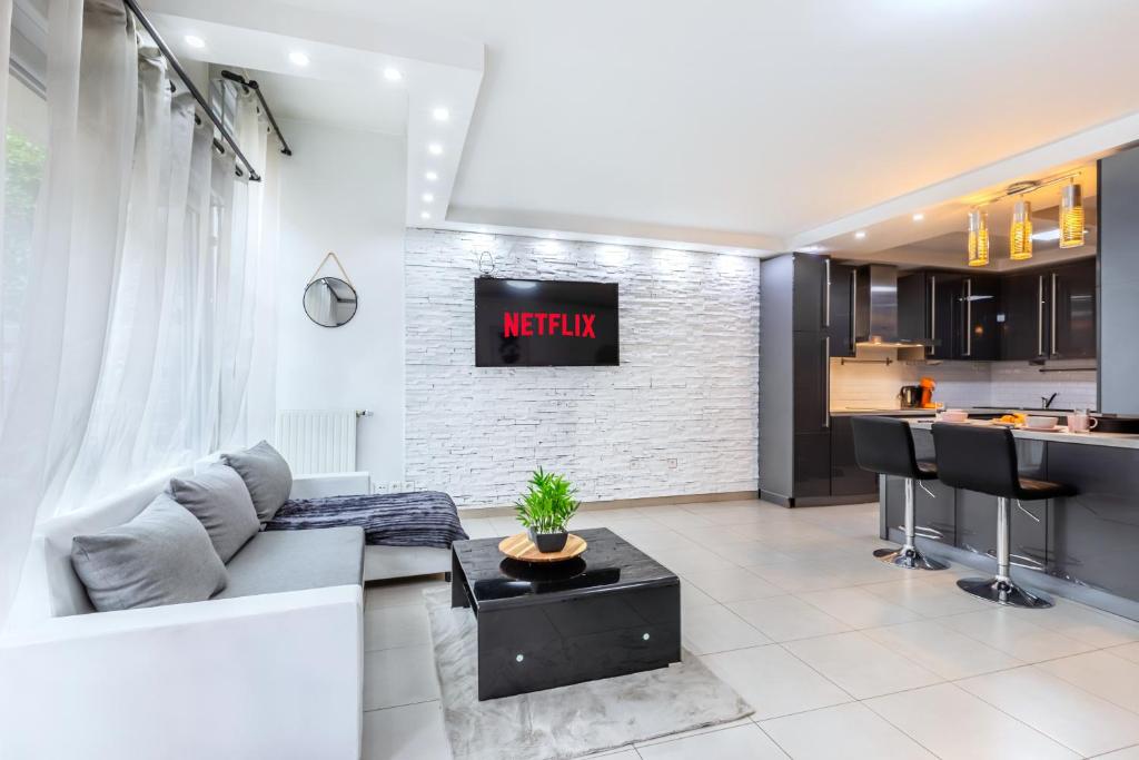 a living room with a couch and a kitchen at Triplex cosy à 20min des Champs Elysées in Gennevilliers