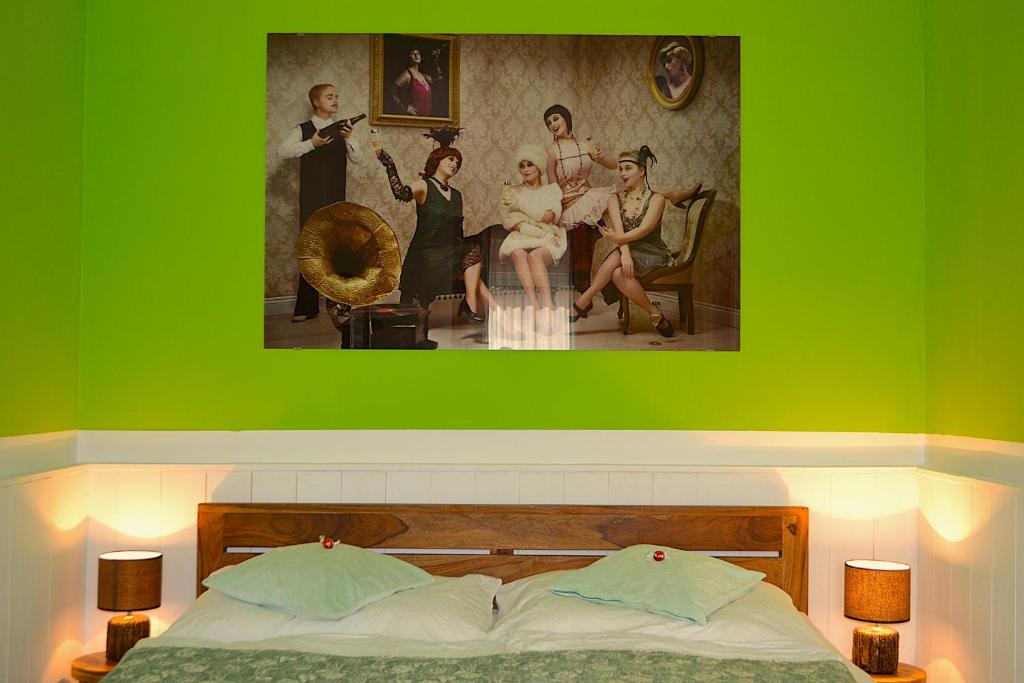 a bedroom with a green wall with a bed and a painting at Ferienwohnungen Halbturn in Halbturn