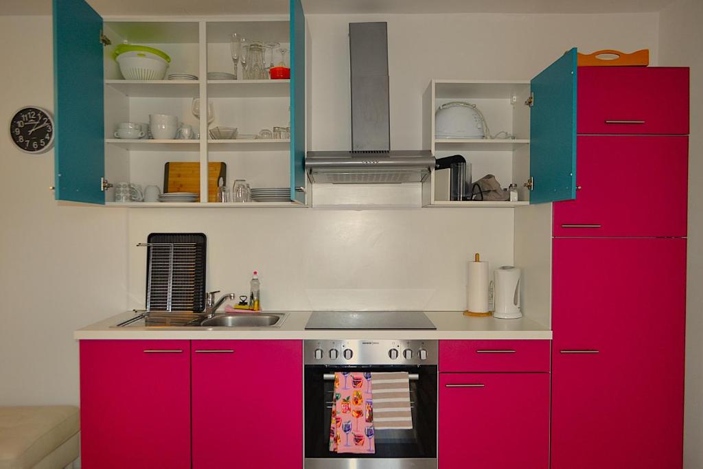 a kitchen with bright red cabinets and a stove at Ferienwohnungen Halbturn in Halbturn