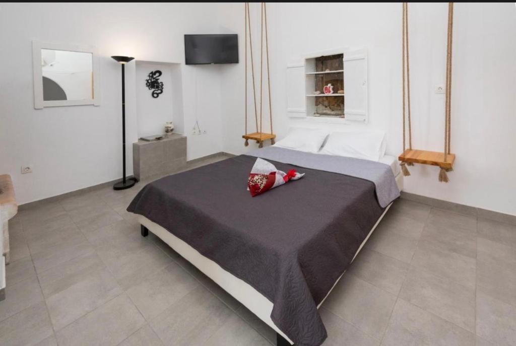 a bedroom with a bed with a red pillow on it at The beautiful Plaka in Plaka Milou