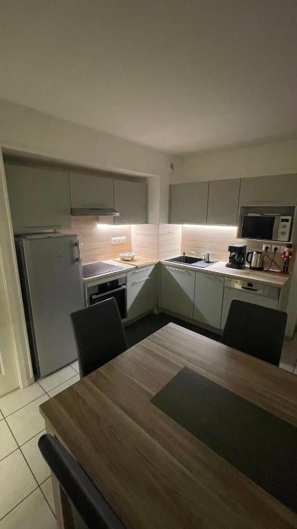une cuisine avec une table avec des chaises et un réfrigérateur dans l'établissement Appartement 65m² idéalement placé pour 6 pers., à Brides-les-Bains