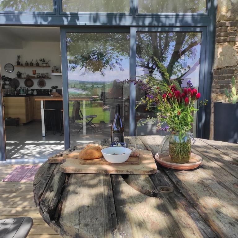 a wooden table with a plate of food on it at Chambre spacieuse Le clos des vignes in Chavanay