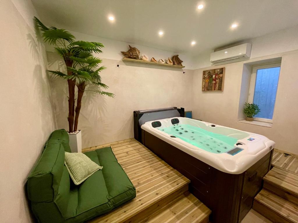 - une baignoire dans une chambre avec un palmier dans l'établissement Apartment, jacuzzi,, à Barjac