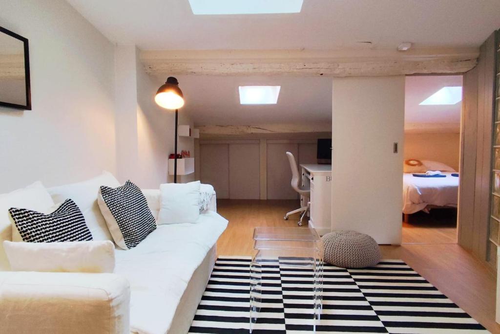 - un salon avec un canapé blanc et un tapis noir et blanc dans l'établissement Nice T2 in the historic heart of Bordeaux, à Bordeaux