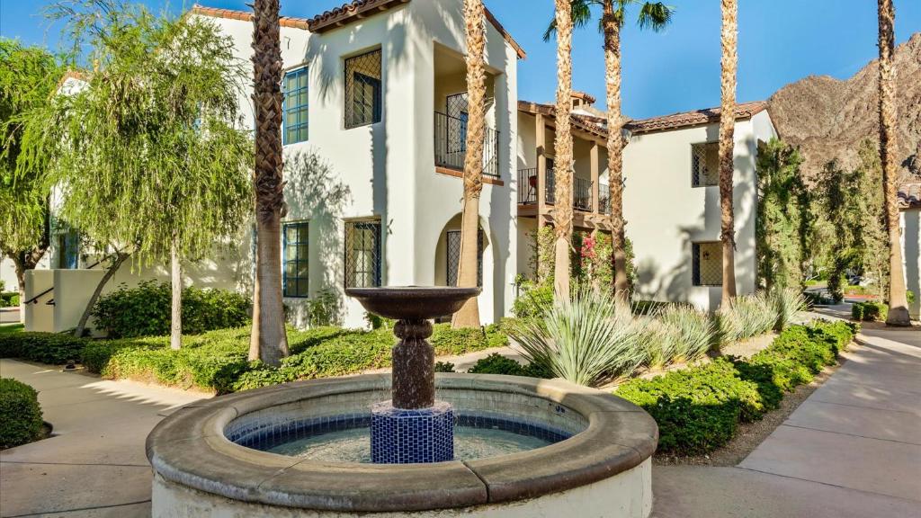 a fountain in front of a building with palm trees at LV250 Upstairs 2 BDR Condo with Private Balcony in La Quinta