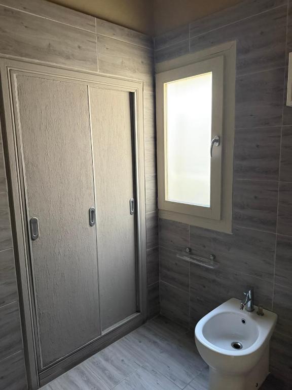ein Badezimmer mit Toilette, Waschbecken und Fenster in der Unterkunft frizzi house in Parabita