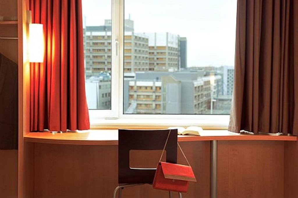 a desk with a chair in front of a window at ibis Birmingham Centre New Street Station Hotel in Birmingham