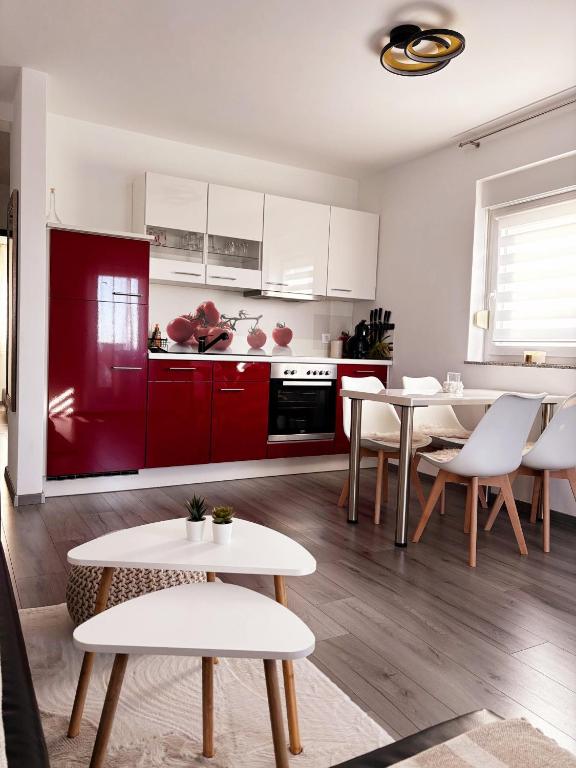 a kitchen with red cabinets and white tables and chairs at Casa Bruno in Vodnjan