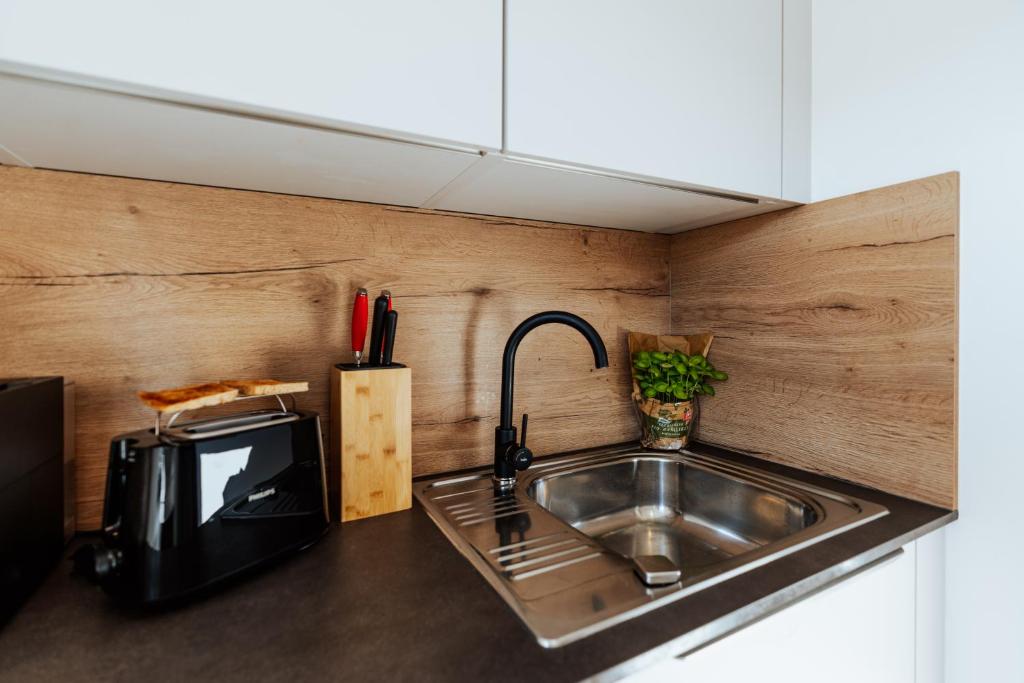 Kuchyň nebo kuchyňský kout v ubytování ArVia Living - Ferienwohnung in Altmünster, zentrale Lage, 7 Min Gehweg zum Traunsee, Balkon, Küche, gratis Parkplatz & WLAN
