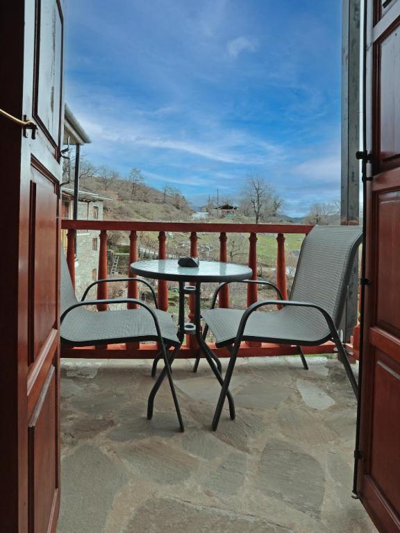 a patio with two chairs and a table on a balcony at Stone Oasis in Tsepelovo