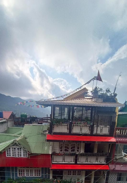 a building with a balcony on top of it at Subba Homestay Sukhia Pokhari Ramjee Road in Sukhia Pokhari