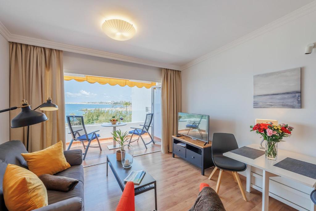 una sala de estar con un sofá y una mesa en Sunsuites Collection - Las Flores, en San Bartolomé