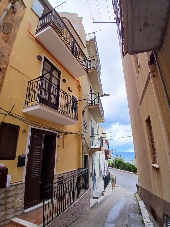 an alley in a building with balconies and a street at Sonalerba Ammare Trabia H H in Trabia