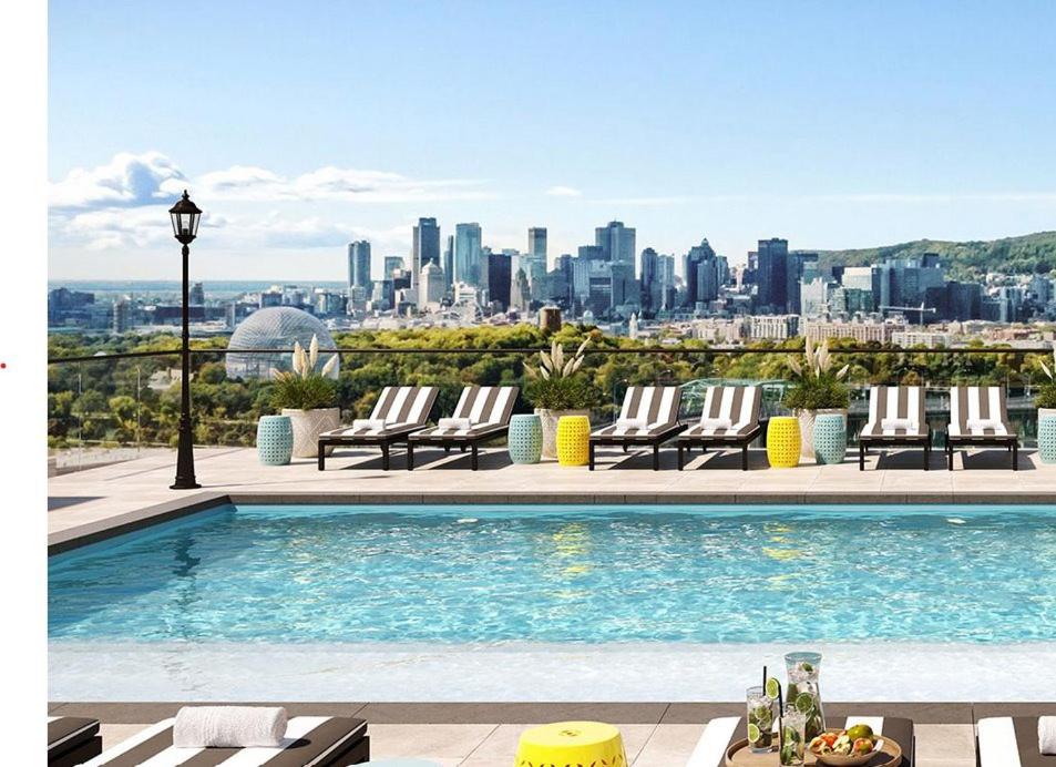 een zwembad met ligstoelen en een skyline van de stad bij Dream Apartment in Longueuil