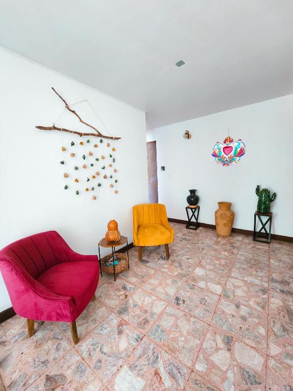 a living room with a red couch and chairs at Habitaciones Casa Bule in Oaxaca City