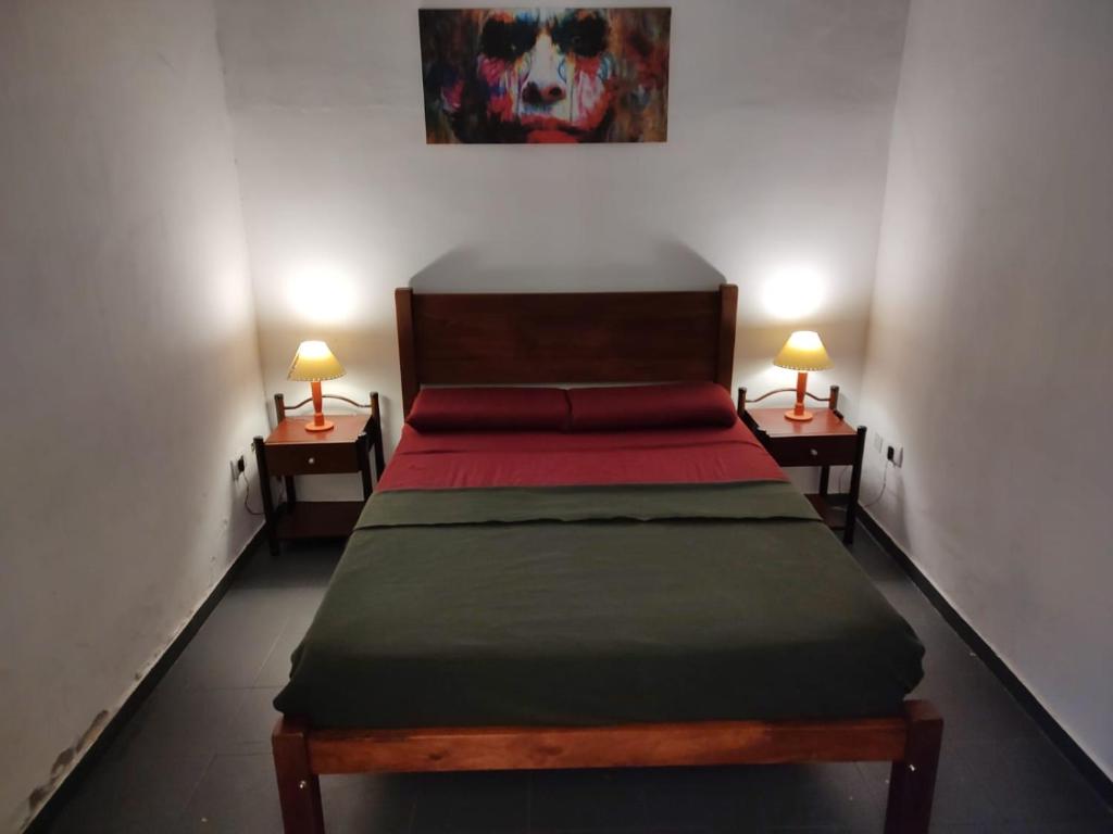 a bedroom with a bed with two lamps on two tables at Hostelmo Hotel in Buenos Aires