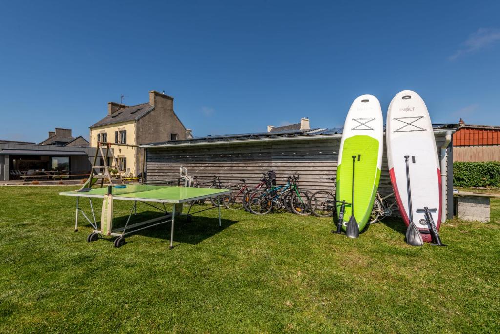 2 planches de surf et une table de ping-pong dans la cour dans l'établissement Villa Léonie Kerlouan, à Kerlouan