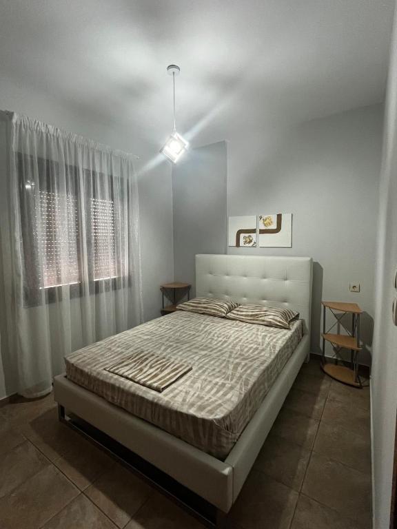a bedroom with a bed in a white room at Veta's House in Olympiada