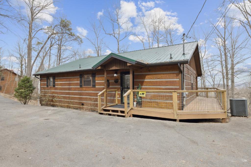 eine große Holzhütte mit Veranda und Gründach in der Unterkunft Secluded Cubs Den Retreat in Wears Valley Sleeps 10 Hot Tub Pool Table Dog Friendly in Sevierville