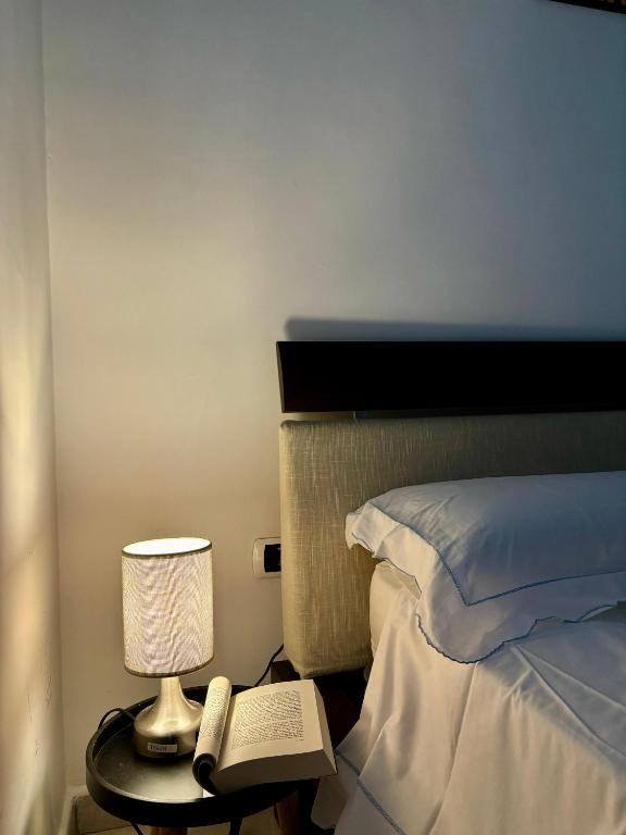 una camera con letto, lampada e libro di Station Comfort House a Pagani