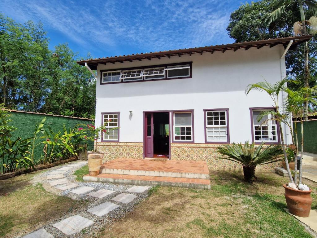 een wit huis met een rode deur bij Casa Colonial Cabore in Paraty