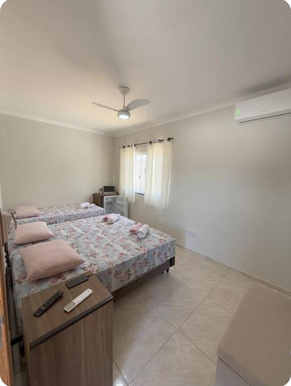 a bedroom with a bed and a table in it at Suítes Nina e Malu in Santa Cruz Cabrália