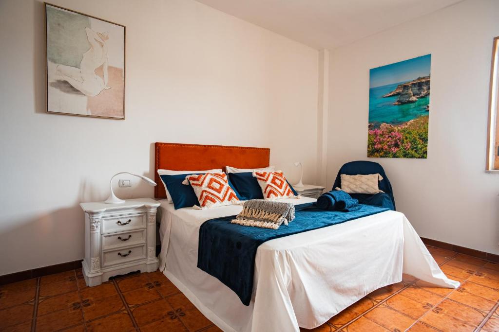 Un dormitorio con una cama y una silla azul. en Il gabbiano, en Otranto